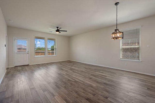 241 Pivot Dr, Taylor, TX 76574 - unfurnished living room featuring ceiling fan, dark wood finished floors, and a chandelier
