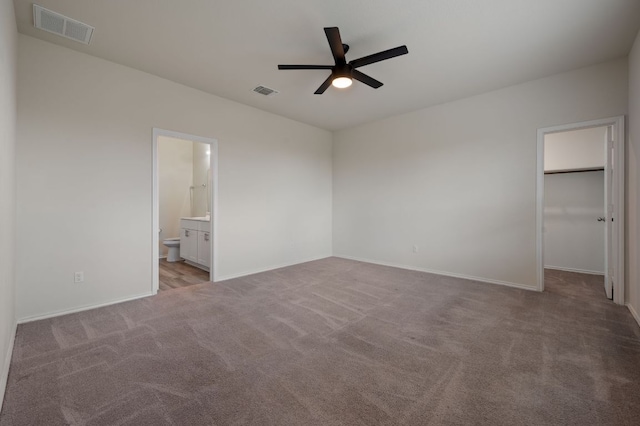 241 Pivot Dr, Taylor, TX 76574 - unfurnished bedroom featuring light colored carpet, a walk in closet, ensuite bath, and a ceiling fan