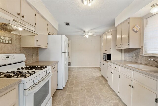 5708 Garden Oaks Dr, Austin, TX 78745 - kitchen with white range with gas cooktop, under cabinet range hood, stainless steel microwave, ceiling fan, and light countertops