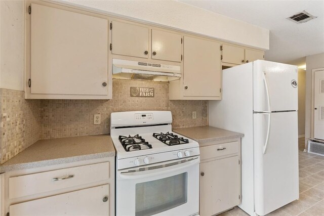5708 Garden Oaks Dr, Austin, TX 78745 - kitchen with white appliances, under cabinet range hood, light countertops, cream cabinetry, and backsplash