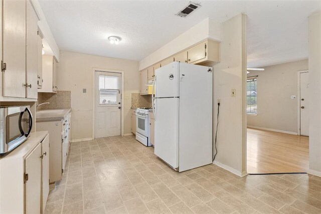 5708 Garden Oaks Dr, Austin, TX 78745 - kitchen with white appliances, light countertops, decorative backsplash, cream cabinetry, and ceiling fan