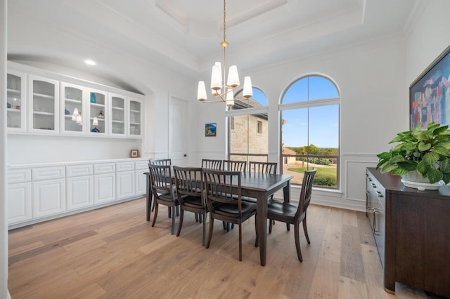 1006 Foothills Dr, Dripping Springs, TX 78620 - dining area featuring a chandelier, ornamental molding, light wood finished floors, wainscoting, and a decorative wall