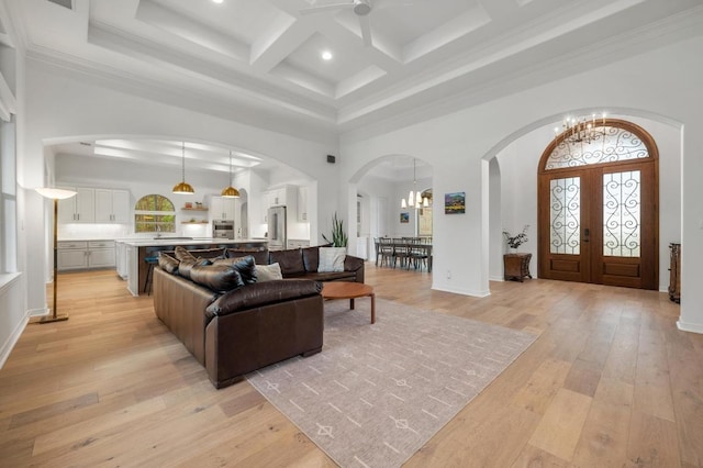 1006 Foothills Dr, Dripping Springs, TX 78620 - living room with a towering ceiling, a chandelier, arched walkways, coffered ceiling, and beam ceiling