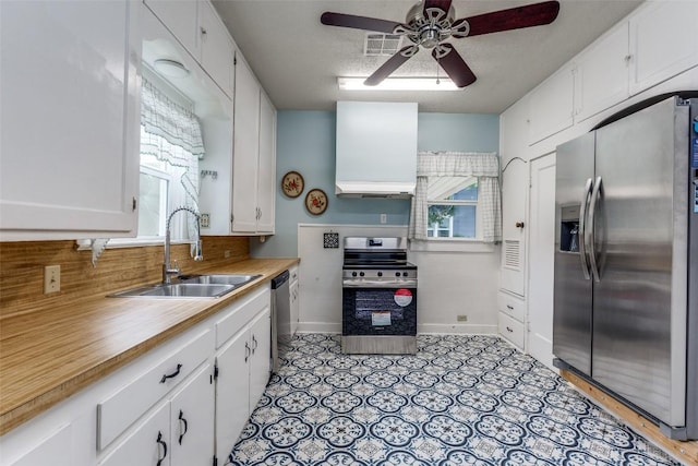 1106 S 11th St, Temple, TX 76504 - kitchen featuring stainless steel appliances, a ceiling fan, white cabinetry, light countertops, and premium range hood