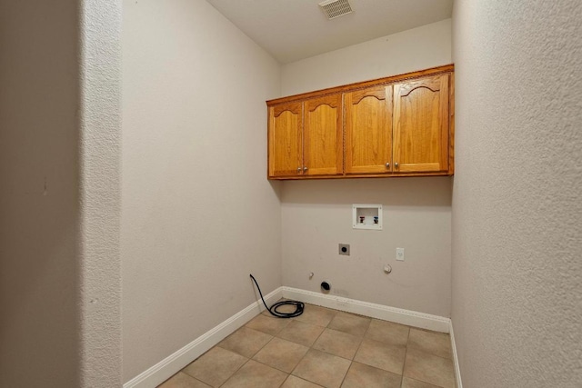 1806 Carey Ave, Taylor, TX 76574 - washroom featuring gas dryer hookup, electric dryer hookup, washer hookup, cabinet space, and light tile patterned flooring