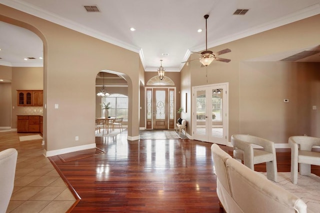 1806 Carey Ave, Taylor, TX 76574 - foyer featuring arched walkways, crown molding, french doors, a ceiling fan, and wood finished floors