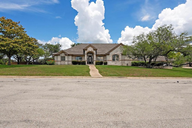 1806 Carey Ave, Taylor, TX 76574 - french country home featuring stone siding and a front yard