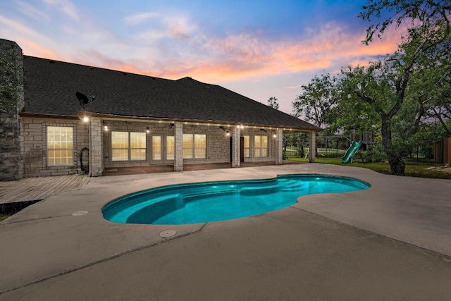 1806 Carey Ave, Taylor, TX 76574 - pool at dusk featuring french doors, a patio, a playground, and an outdoor pool