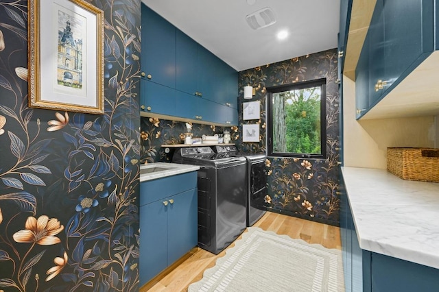1001 Madrone Rd, West Lake Hills, TX 78746 - laundry room featuring cabinet space, wallpapered walls, separate washer and dryer, and wood finished floors