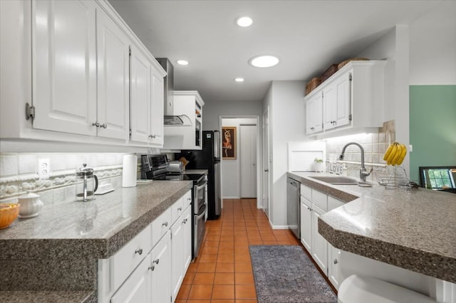 225 Spanish Oak Dr, Georgetown, TX 78628 - kitchen with stainless steel appliances, wall chimney exhaust hood, tasteful backsplash, white cabinetry, and recessed lighting