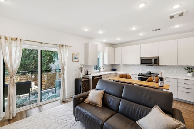 4802 S Congress Ave Unit 215, Austin, TX 78745 - kitchen featuring stainless steel appliances, light countertops, backsplash, modern cabinets, and recessed lighting