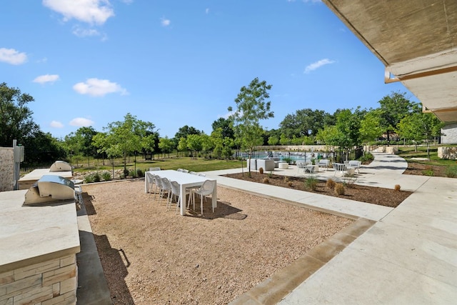 4802 S Congress Ave Unit 215, Austin, TX 78745 - view of patio with an outdoor kitchen, outdoor dining area, and view of wooded area