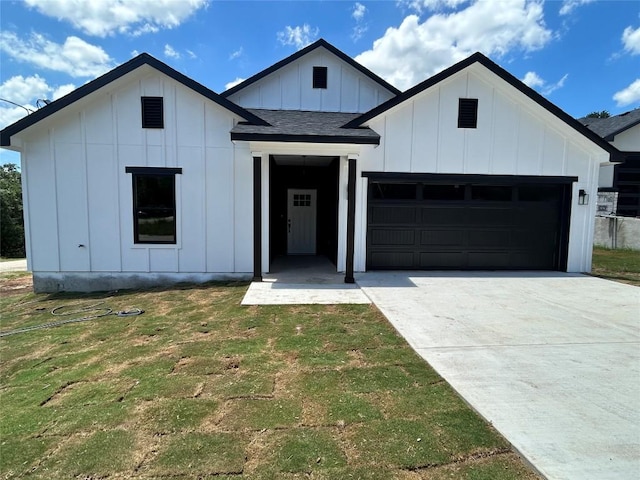 102 Halawa Ct, Bastrop, TX 78602 - modern inspired farmhouse with board and batten siding, a garage, driveway, a front yard, and roof with shingles