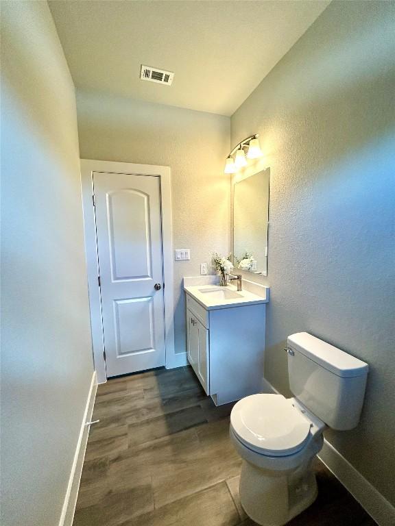 102 Halawa Ct, Bastrop, TX 78602 - half bath featuring vanity, wood finished floors, and a textured wall