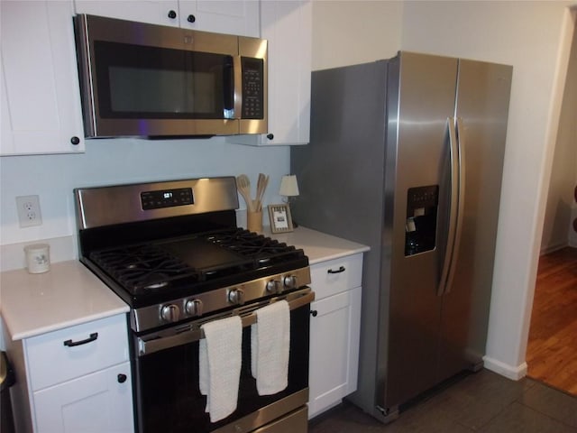 905 W Live Oak St, Austin, TX 78704 - kitchen featuring stainless steel appliances, white cabinets, light countertops, and dark wood-style floors