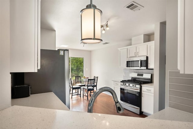 2004 Yaupon Trl, Cedar Park, TX 78613 - kitchen with stainless steel appliances, white cabinetry, backsplash, and light stone countertops