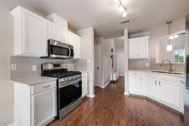 2004 Yaupon Trl, Cedar Park, TX 78613 - kitchen featuring appliances with stainless steel finishes, dark wood-style flooring, backsplash, light countertops, and white cabinetry