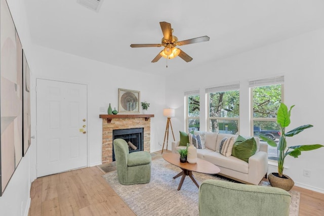 2414 Longview St Unit 101, Austin, TX 78705 - living room featuring light wood-style floors, a stone fireplace, and ceiling fan
