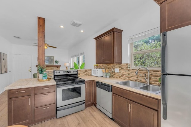 2414 Longview St Unit 101, Austin, TX 78705 - kitchen with appliances with stainless steel finishes, a peninsula, tasteful backsplash, light countertops, and recessed lighting