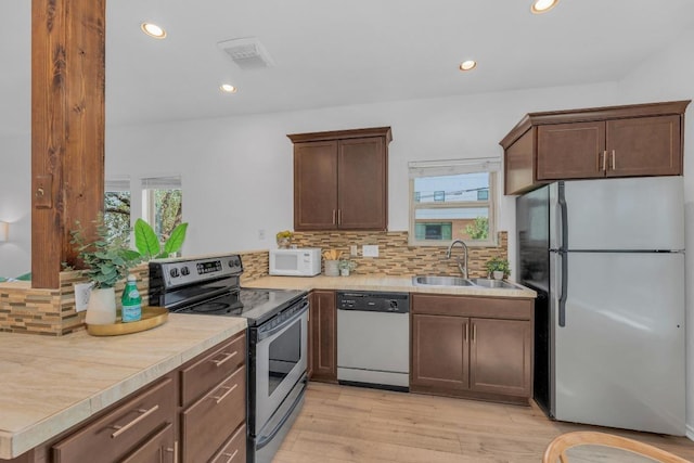 2414 Longview St Unit 101, Austin, TX 78705 - kitchen featuring stainless steel appliances, backsplash, light wood-style floors, recessed lighting, and light countertops