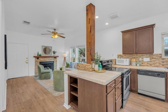 2414 Longview St Unit 101, Austin, TX 78705 - kitchen featuring white appliances, light wood-style flooring, light countertops, tasteful backsplash, and a fireplace