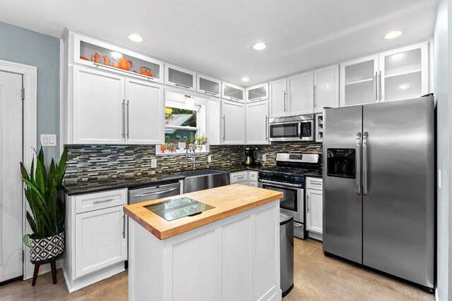 1214 Arthur Stiles Rd, Austin, TX 78721 - kitchen with stainless steel appliances, butcher block countertops, backsplash, white cabinets, and recessed lighting