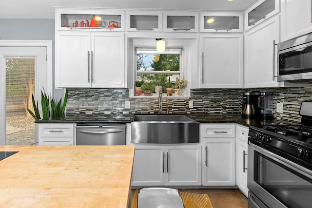 1214 Arthur Stiles Rd, Austin, TX 78721 - kitchen featuring appliances with stainless steel finishes, white cabinetry, decorative backsplash, and glass insert cabinets
