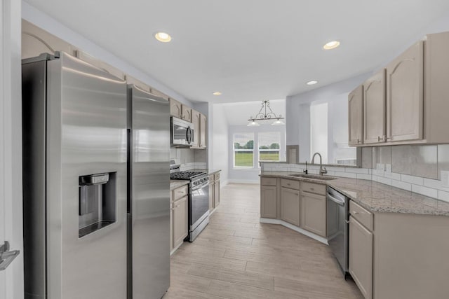 131 Martin Crossing Dr, Cedar Creek, TX 78612 - kitchen featuring appliances with stainless steel finishes, recessed lighting, light wood-type flooring, tasteful backsplash, and light stone countertops