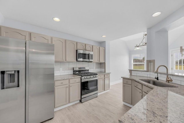 131 Martin Crossing Dr, Cedar Creek, TX 78612 - kitchen with appliances with stainless steel finishes, decorative backsplash, light stone countertops, light wood finished floors, and recessed lighting