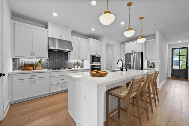 149 Beryl Way, Dripping Springs, TX 78620 - kitchen featuring ventilation hood, appliances with stainless steel finishes, light wood-style floors, recessed lighting, and tasteful backsplash