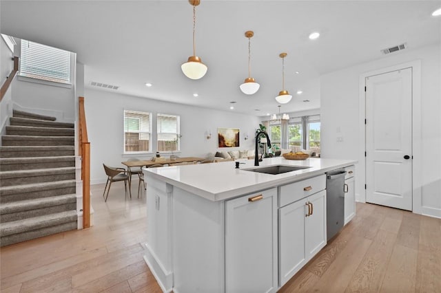 149 Beryl Way, Dripping Springs, TX 78620 - kitchen with stainless steel dishwasher, recessed lighting, light wood-style flooring, light countertops, and white cabinets