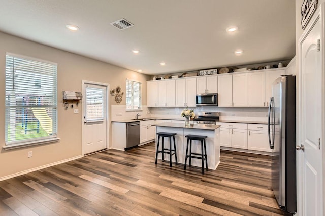 501 Goat Willow Ln, Georgetown, TX 78626 - kitchen featuring appliances with stainless steel finishes, a center island, dark wood-style flooring, recessed lighting, and white cabinets