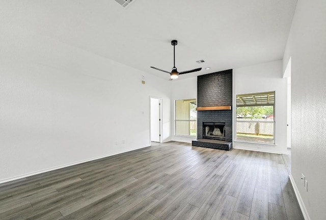 1105 Madrone Trl, Leander, TX 78641 - unfurnished living room featuring dark wood finished floors, a ceiling fan, and a fireplace
