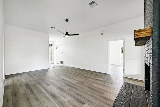 1105 Madrone Trl, Leander, TX 78641 - unfurnished living room with ceiling fan, a fireplace, and wood finished floors