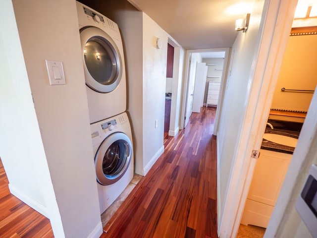 2303 Eastside Dr # 209, Austin, TX 78704 - laundry room featuring stacked washer and clothes dryer and wood finished floors