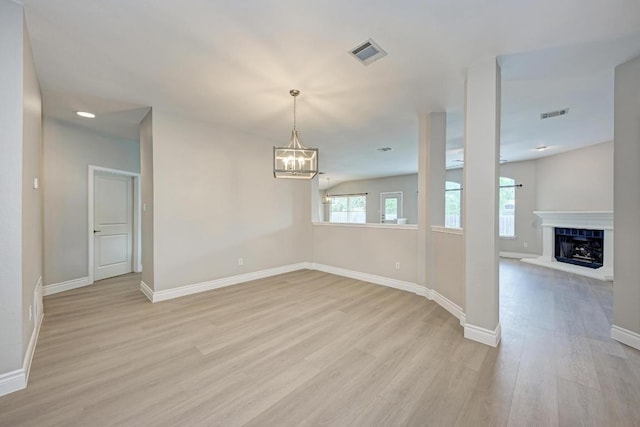 4408 Tello Path, Austin, TX 78749 - unfurnished dining area featuring light wood-style floors, a chandelier, and a fireplace with raised hearth