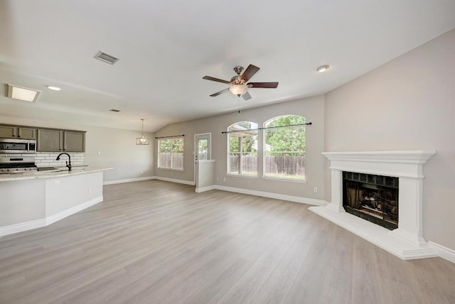 4408 Tello Path, Austin, TX 78749 - unfurnished living room featuring a premium fireplace, light wood-style floors, a ceiling fan, recessed lighting, and vaulted ceiling