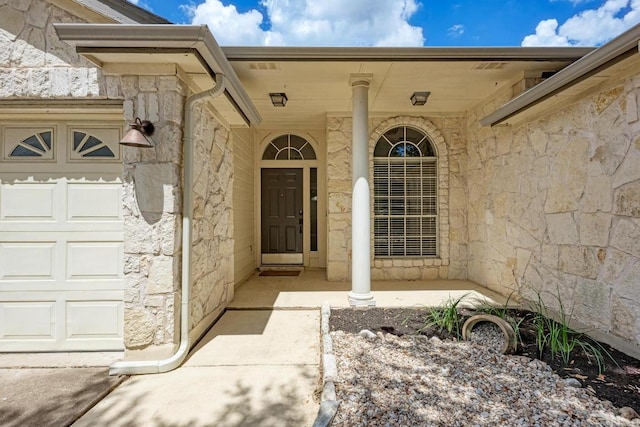4408 Tello Path, Austin, TX 78749 - entrance to property featuring stone siding, an attached garage, and a porch
