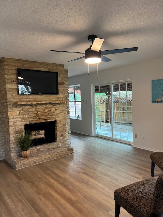 6506 Clubway Ln, Austin, TX 78745 - living room with ceiling fan, wood finished floors, a textured ceiling, and a fireplace