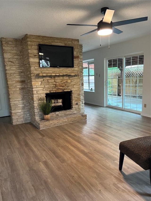 6506 Clubway Ln, Austin, TX 78745 - living area featuring ceiling fan, wood finished floors, a fireplace, and a textured ceiling