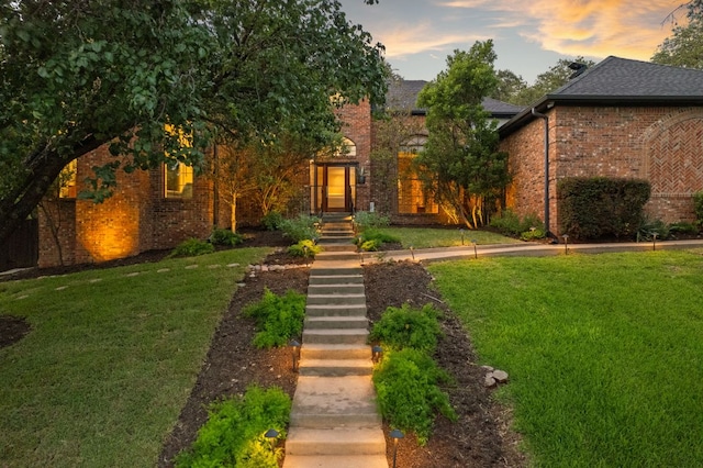 5301 Backtrail Dr, Austin, TX 78731 - view of front of home featuring brick siding, a yard, and roof with shingles