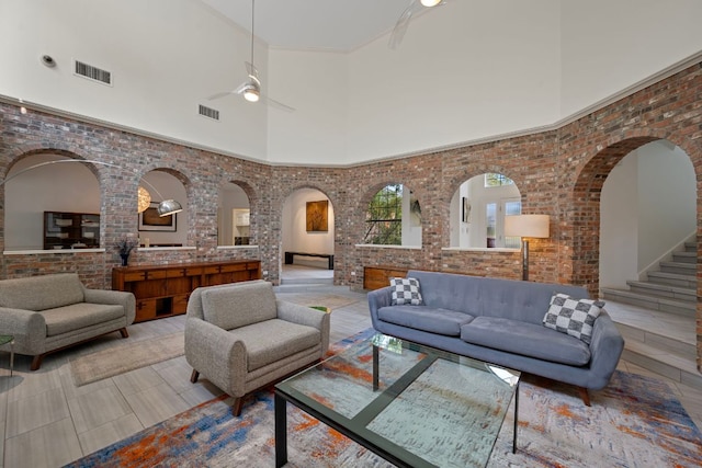 5301 Backtrail Dr, Austin, TX 78731 - tiled living area with brick wall, a high ceiling, ceiling fan, and arched walkways