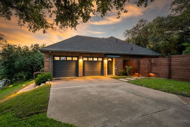 5301 Backtrail Dr, Austin, TX 78731 - view of front of property featuring a garage, a shingled roof, concrete driveway, and brick siding