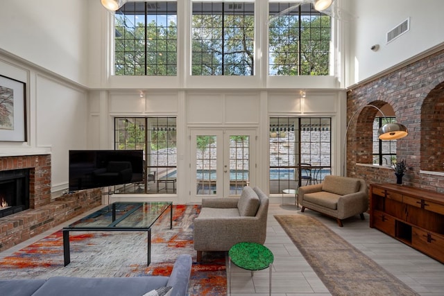 5301 Backtrail Dr, Austin, TX 78731 - living room with a high ceiling, a decorative wall, a fireplace, plenty of natural light, and french doors