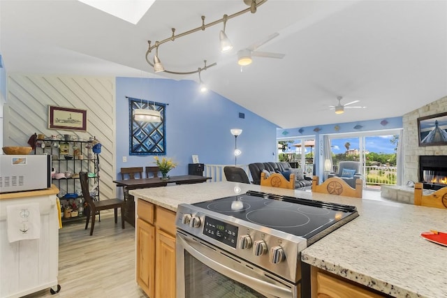 200 Full Moon Unit 4, Horseshoe Bay, TX 78657 - kitchen with electric range, open floor plan, a ceiling fan, vaulted ceiling, and a skylight