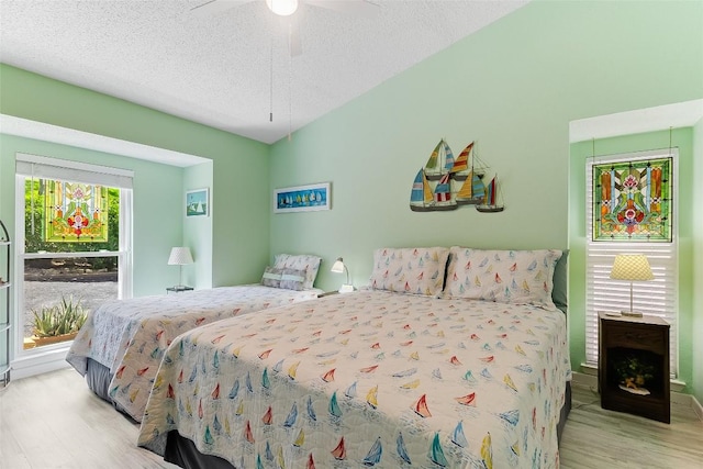 200 Full Moon Unit 4, Horseshoe Bay, TX 78657 - bedroom featuring wood finished floors, a textured ceiling, and a ceiling fan
