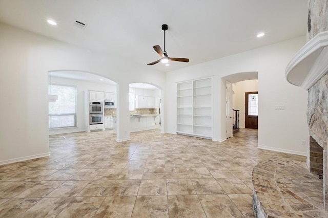 3340 Marcasite Dr, Round Rock, TX 78681 - unfurnished living room with built in shelves, a ceiling fan, arched walkways, and recessed lighting