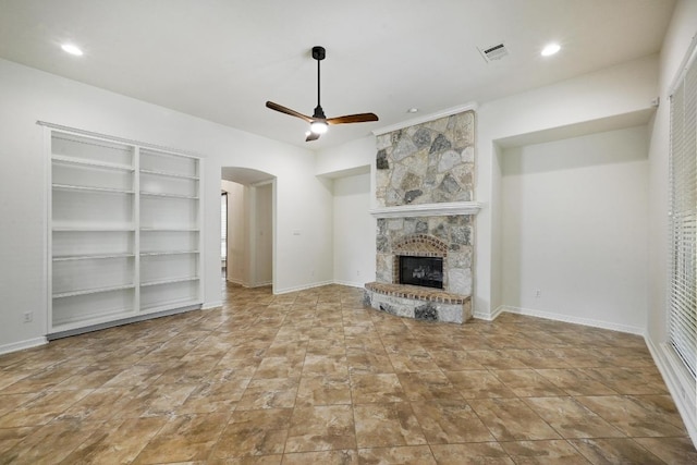 3340 Marcasite Dr, Round Rock, TX 78681 - unfurnished living room featuring arched walkways, ceiling fan, a fireplace, built in shelves, and recessed lighting