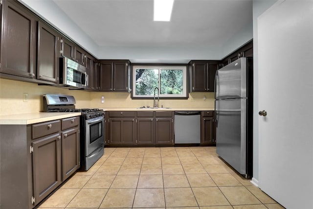 1928 Ramona Cir, San Marcos, TX 78666 - kitchen with stainless steel appliances, light countertops, light tile patterned flooring, and dark brown cabinetry