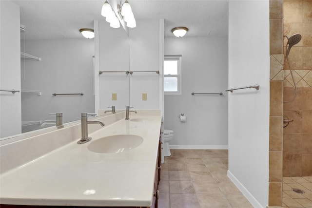 1928 Ramona Cir, San Marcos, TX 78666 - bathroom featuring double vanity, tile patterned floors, tiled shower, a chandelier, and a textured ceiling